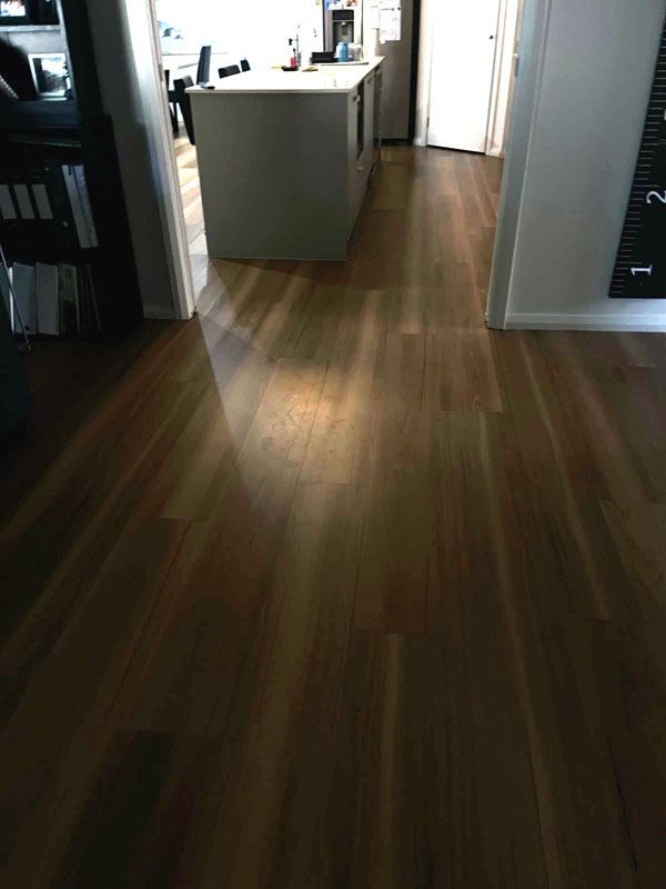 Timber floor cleaned through a hallway toward the kitchen