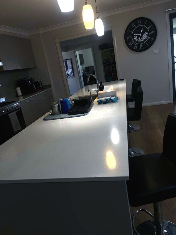 Stone kitchen island benchtop wiped down after a clean